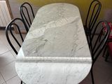 a marble table and chairs in a room with a yellow wall