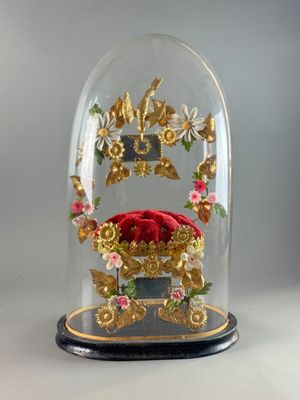 a glass clochet with a red cushion under it