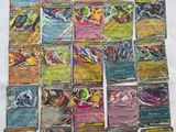 a bunch of pokemon cards sitting on top of a white sheet