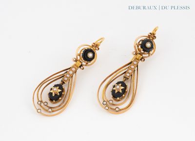a pair of black and gold earrings on a white surface