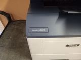 a printer that is sitting on the floor next to a chair
