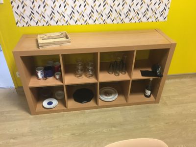 une étagère en bois sur laquelle sont posées de nombreuses bouteilles et verres