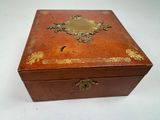 a small wooden box with a gold decoration on it