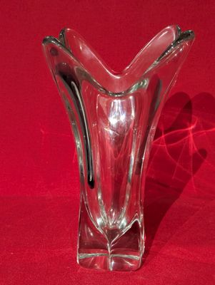 un vase en verre posé sur une surface rouge
