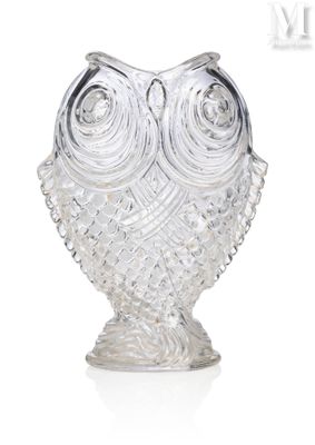 une figurine de chouette en verre posée sur une surface blanche