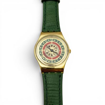 une image représentant une montre-bracelet dorée et verte sur fond blanc