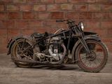 a old motorcycle that is parked in front of a brick wall