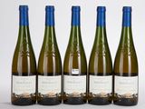 quatre bouteilles de vin sont alignées sur une surface blanche