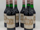 six bouteilles de vin rouge sont alignées sur une table