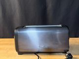 a close up of a toaster on a wooden table with a black background