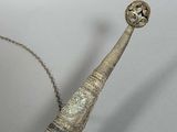 a long horn shaped object with a chain around it