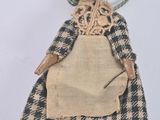 an old fashioned doll with a plaid dress and a hat