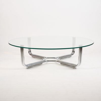 a glass coffee table with chrome legs and a glass top