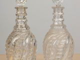 two glass bottles that are sitting on a table