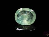 a close up of a green gemstone on a black surface