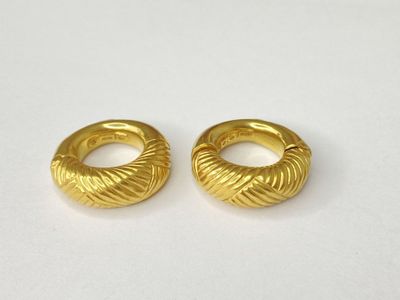 a pair of gold toned hoop earrings on a white surface