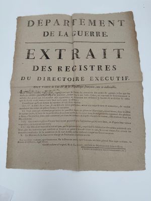 un vieux document sur lequel figurent des inscriptions noires, posé sur une table