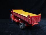 a red and yellow toy truck on a black background