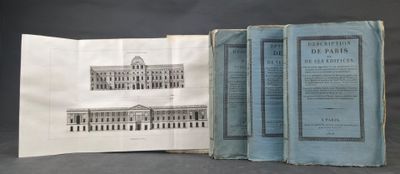 three old books are open on a table with a black background