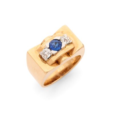 gros plan d'une bague en or avec un saphir et des diamants