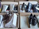 Plusieurs paires de chaussures pour homme sont rangées dans des boîtes posées sur une table