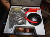 someone is holding a tool in a case with a lot of tools inside of it