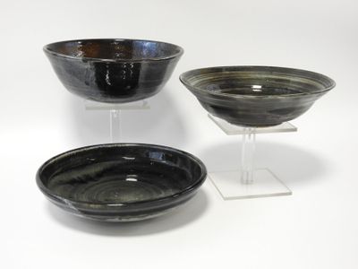 trois bols noirs et blancs posés sur une surface blanche