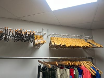 hanging clothes on a rack in a room with a skylight
