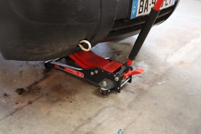 une voiture posée sur un pont élévateur dans le garage