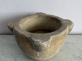 a small stone bowl sitting on a marble table