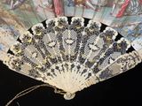 un éventail en dentelle noir et blanc orné d'une peinture