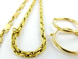 trois bijoux en or posés sur une surface blanche