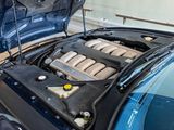 a blue car with its hood open and the engine in the trunk