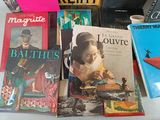 several books are stacked on a table with a cup of coffee