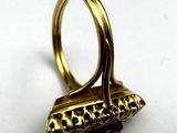 an image of a gold ring with a black stone in it