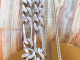 a person holding a bunch of silver bracelets on their arm