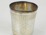 a silver cup that is sitting on a white surface