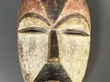 une image représentant un masque en bois sur lequel est peint un visage