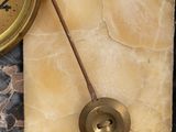 a clock that is sitting on a shelf in front of a wall