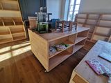 une pièce avec un bureau, une bibliothèque et d'autres objets posés par terre