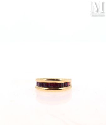 a close up of a gold ring with a red stone in it