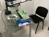 un bureau en verre sur lequel se trouvent un ordinateur et une imprimante