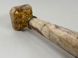 a wooden handle with a gold decoration on it