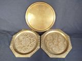 trois assiettes dorées ornées d'un motif floral sur fond bleu
