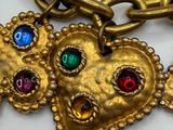 a close up of a gold chain with a heart on it