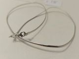 boucles d'oreilles créoles plaquées argent sur un fond blanc, accompagnées d'une étiquette