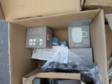 a cardboard box filled with electronics and a cup of coffee