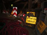 a pile of construction equipment in a room with a caution sign