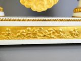 a white and gold clock with a gold decoration on it