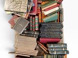 une boîte remplie de vieux livres posée sur une surface blanche